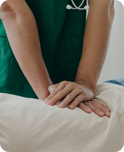 Imagem de uma pessoa deitada com um profissional pressionando a região da lombar