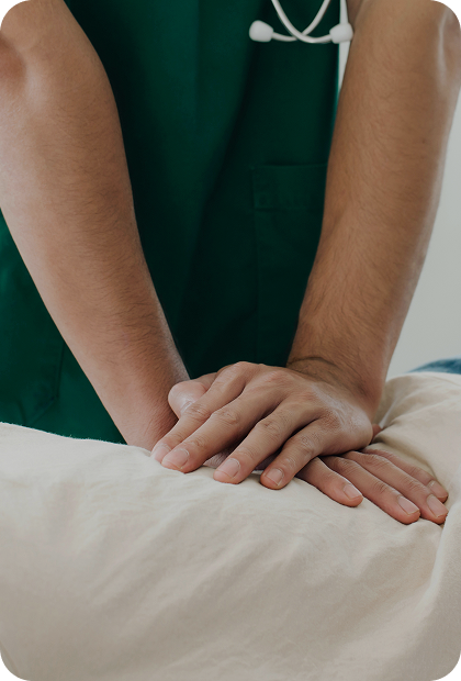 imagem com paciente deitado e profissional com as duas mãos apoiadas e pressionando na região da lombar
