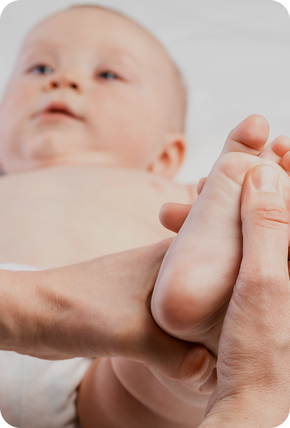 imagem com um bebê e profissional segurando e pressionando um dos pés